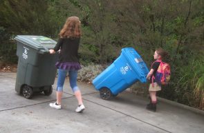 kids hauling trash cans CROP