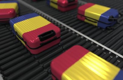 Many travel suitcases featuring flag of Romania on roller conveyer. Romanian tourism conceptual 3D rendering