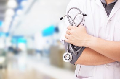 Doctor with a stethoscope in the hands and hospital background