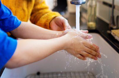 Boy washing his hands to lessen the chance of COVID-19